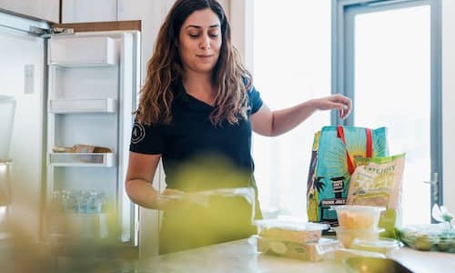 lifestyle image of a woman packing groceries