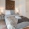 Dog-Friendly Luxury Apartments in Downtown Los Angeles, CA - AVEN - Bedroom with Engineered Wood Plank Flooring, Large Rug, Bed, Nightstands, Lamps, Wall Decor, and Large Windows,