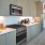 Downtown Los Angeles, CA, Studios for Rent - AVEN - Kitchen with Engineered Wood Plank Flooring, Custom Cabinetry with LED Lighting, Range, Microwave, and Refrigerator.